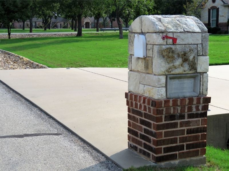  Brick masonry mailbox with integrated metal house numbers, a decorative cap, and coordinated brickwork designed to complement a home in Birmingham, Alabama.
